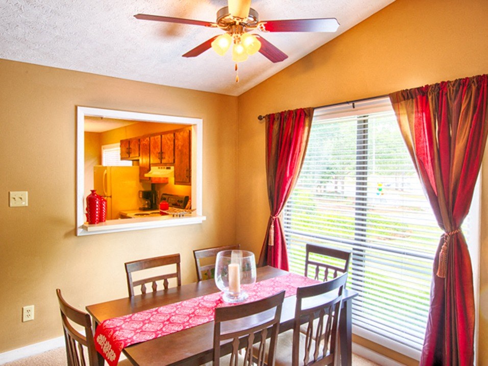 dining area in apartment with large window and overhead lighting