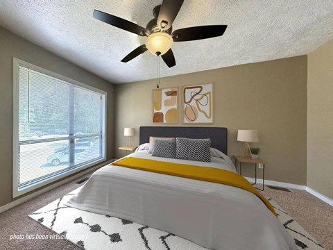A bedroom with a large bed and a ceiling fan.