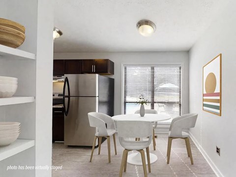 A kitchen with a table and chairs in front of a window.