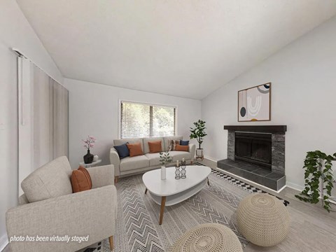A living room with a grey sofa, a white coffee table, and a fireplace.