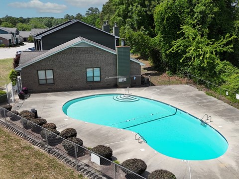 A swimming pool in front of a house.