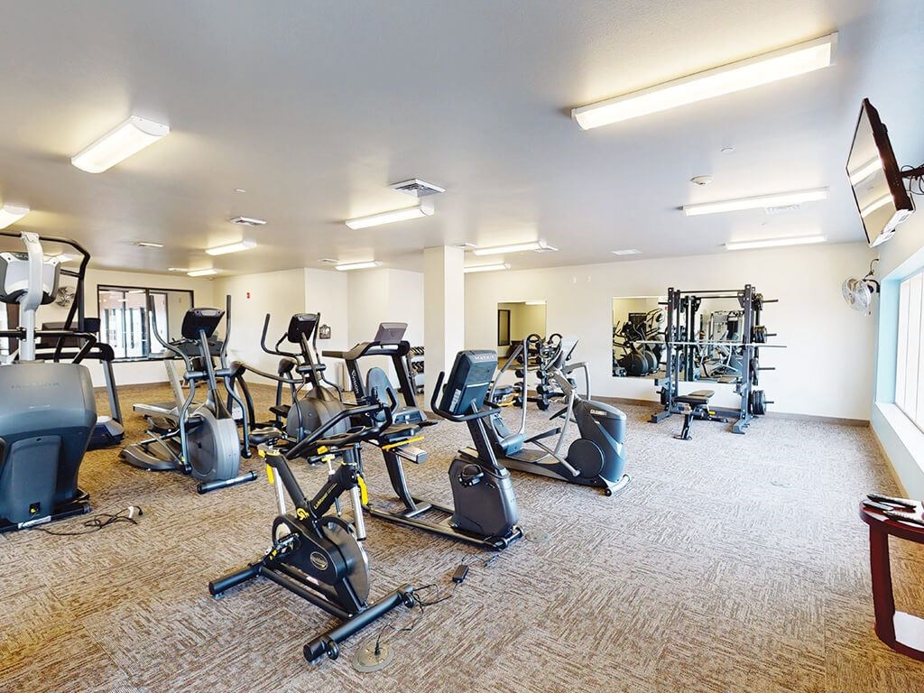 A spacious gym with a variety of cardio exercise equipment The Plaza Apartments.
