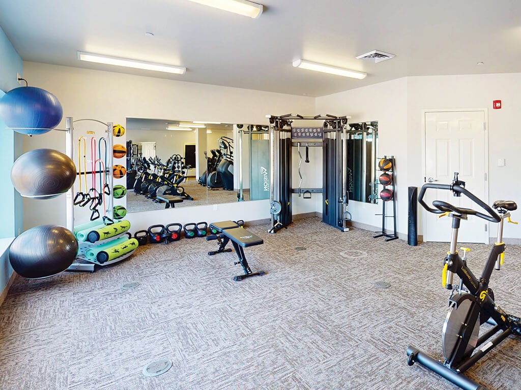 An exercise room with weights at The Plaza Apartments.