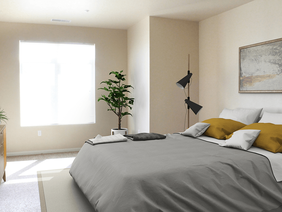 a bedroom with a large bed and a plant in the corner of the room