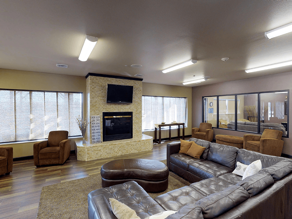 clubhouse with couches chairs and a fireplace