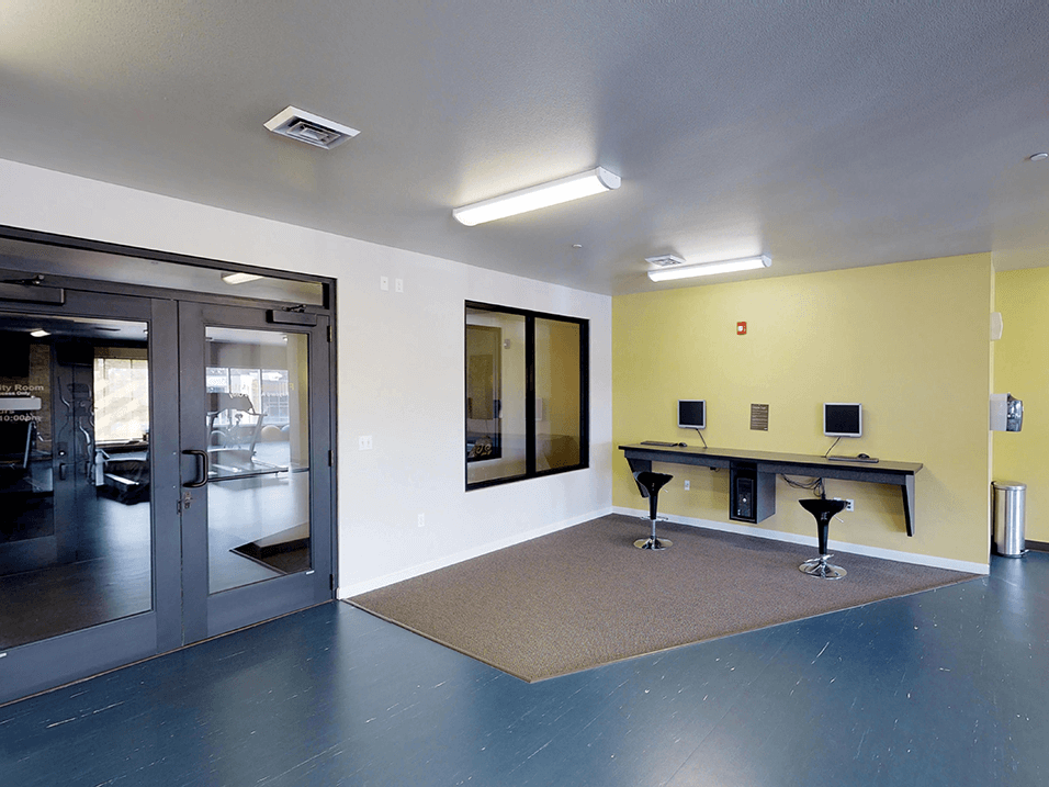a room with a door and two tables with stools