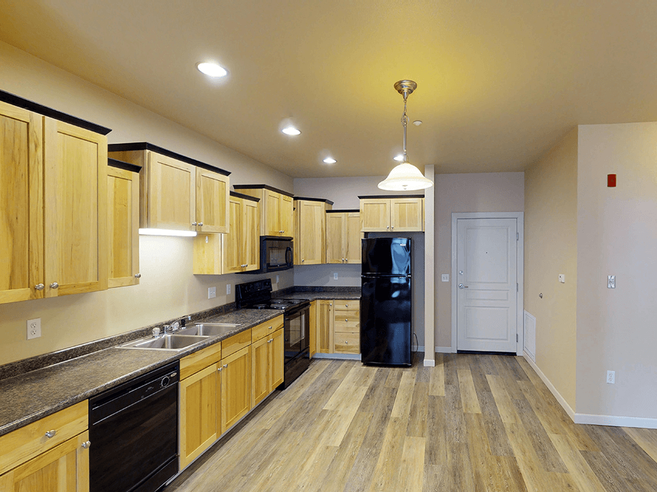 a kitchen with wooden cabinets and black appliances