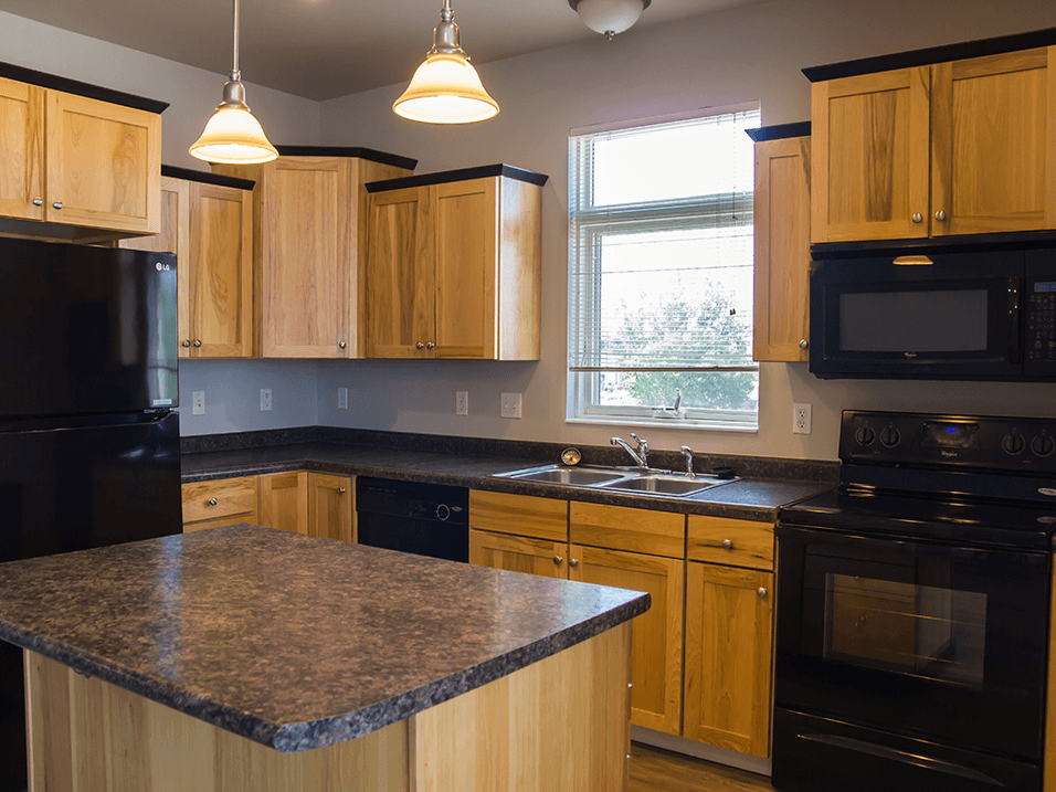 a kitchen with wooden cabinets and black appliances