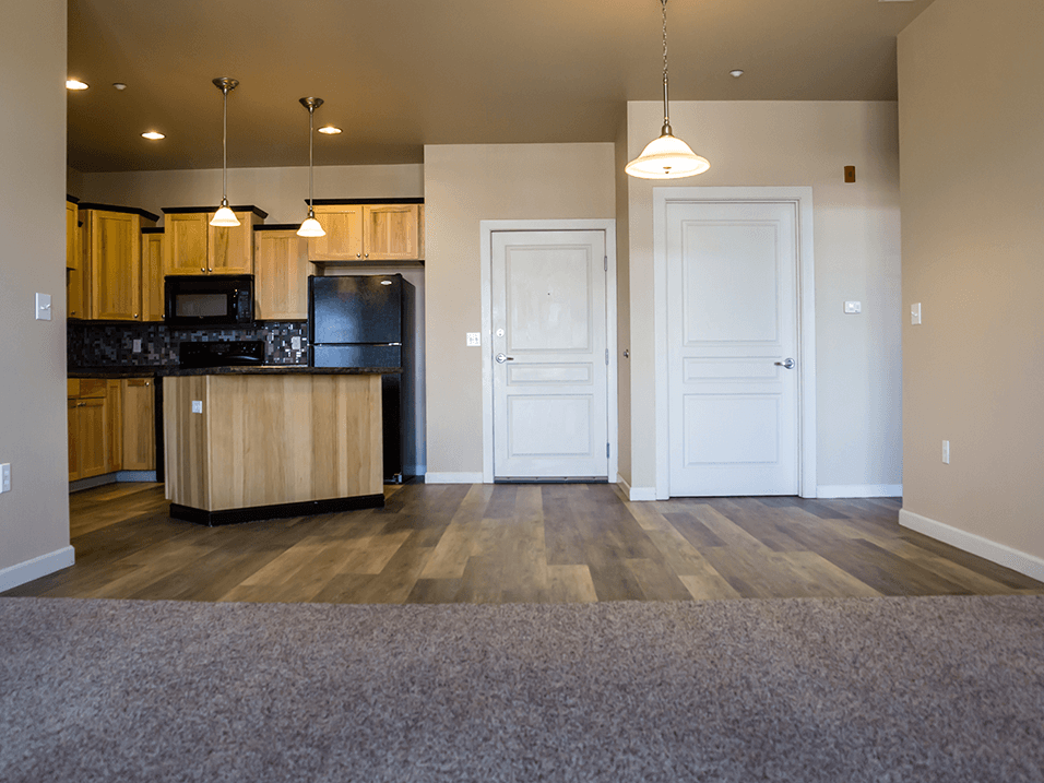 an open kitchen and living room with hardwood flooring