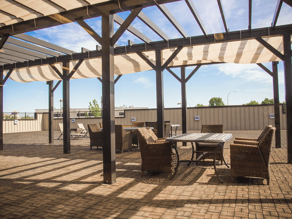 a patio with a wooden table and chairs