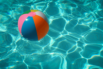 A beach ball floating in a pool of water.