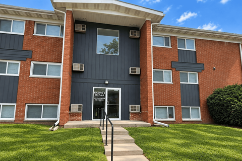 A red brick building with a black door and windows.