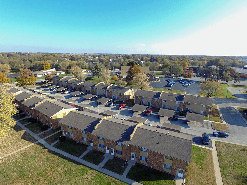 A row of houses with a parking lot in front.