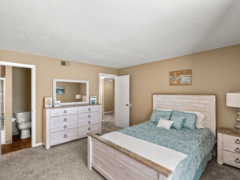 a bedroom with a bed and a bathroom with a toilet