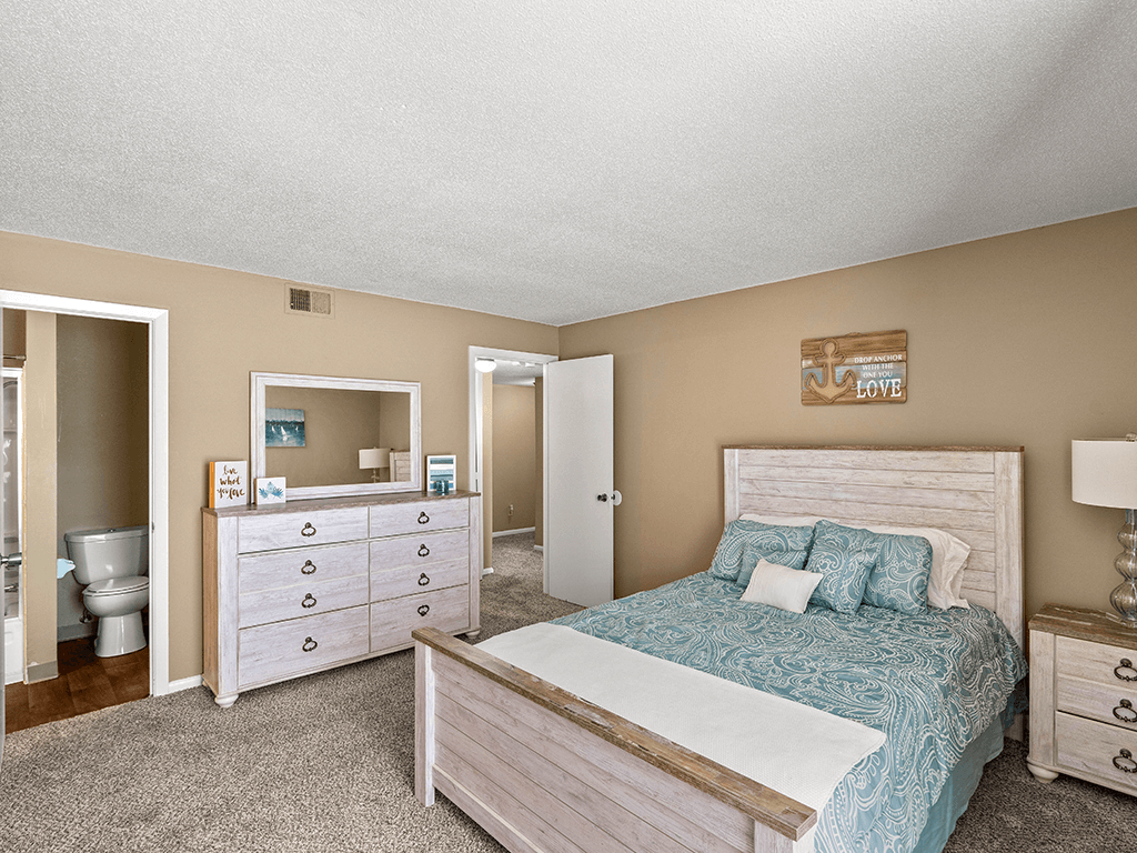 a bedroom with a bed and a bathroom with a toilet