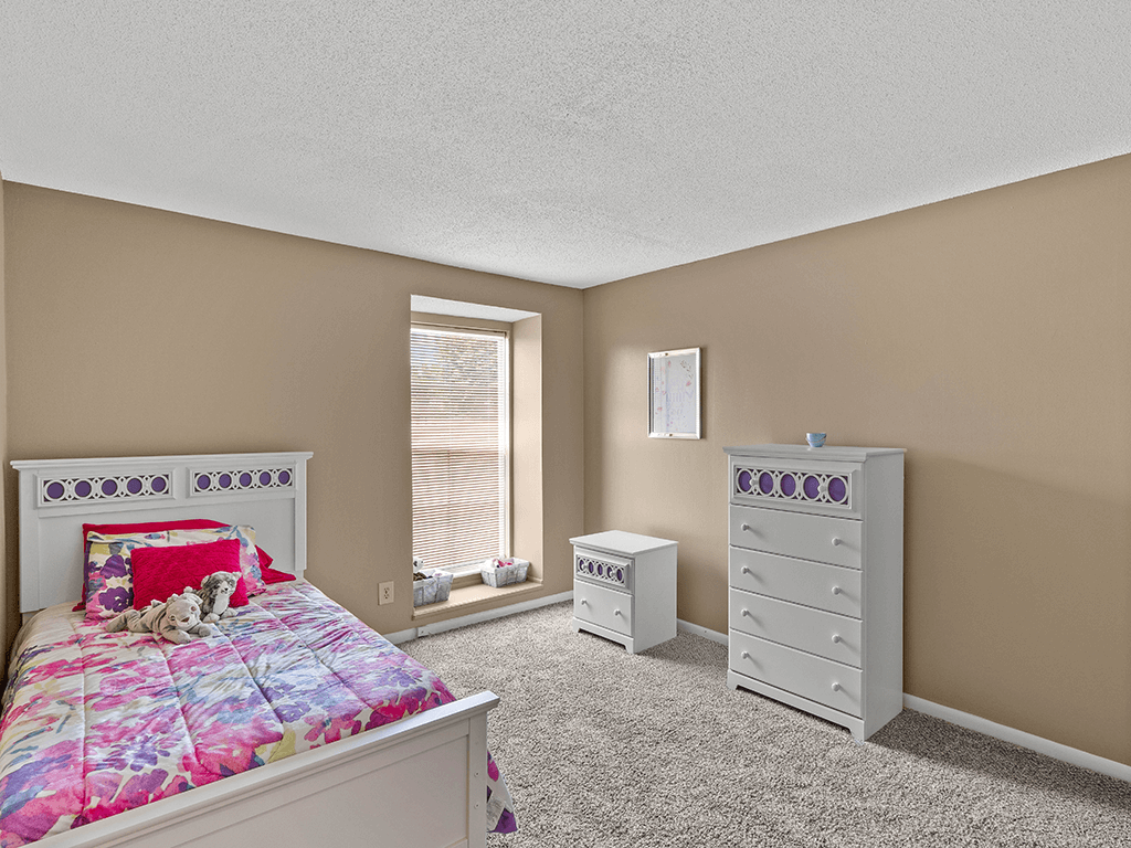 a bedroom with a bed and a dresser