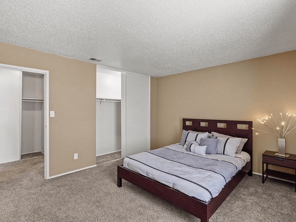 a bedroom with a bed and a nightstand with a lamp