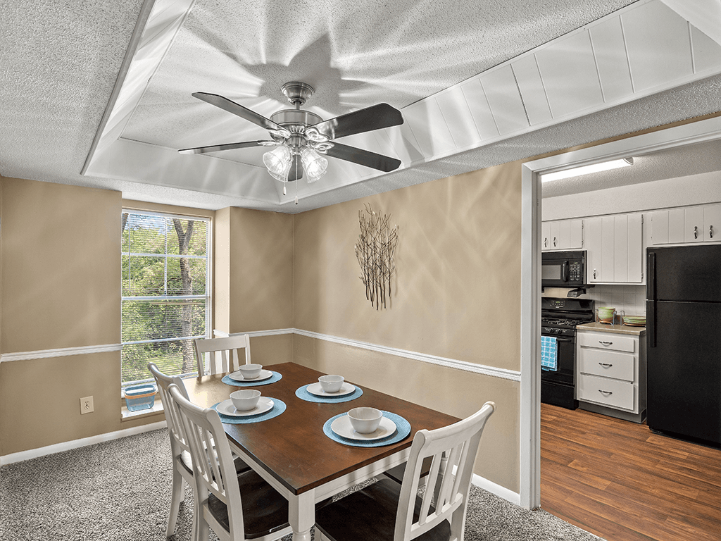 a dining room with a table and chairs and a ceiling fan