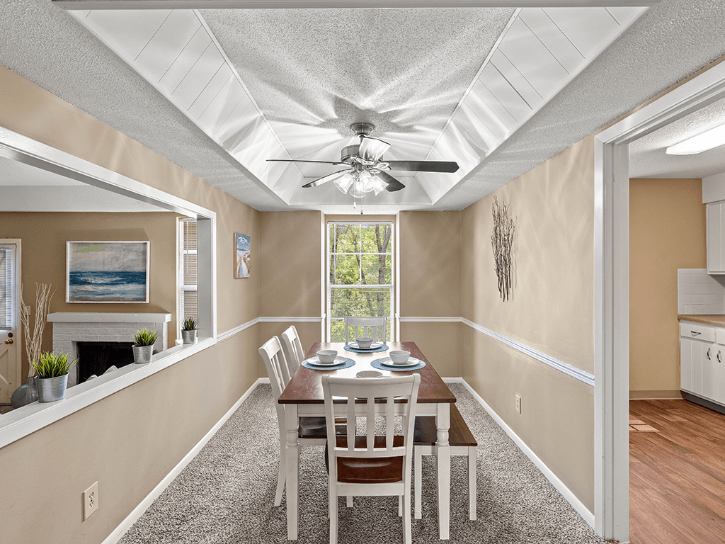 a dining room with a table and chairs and a ceiling fan