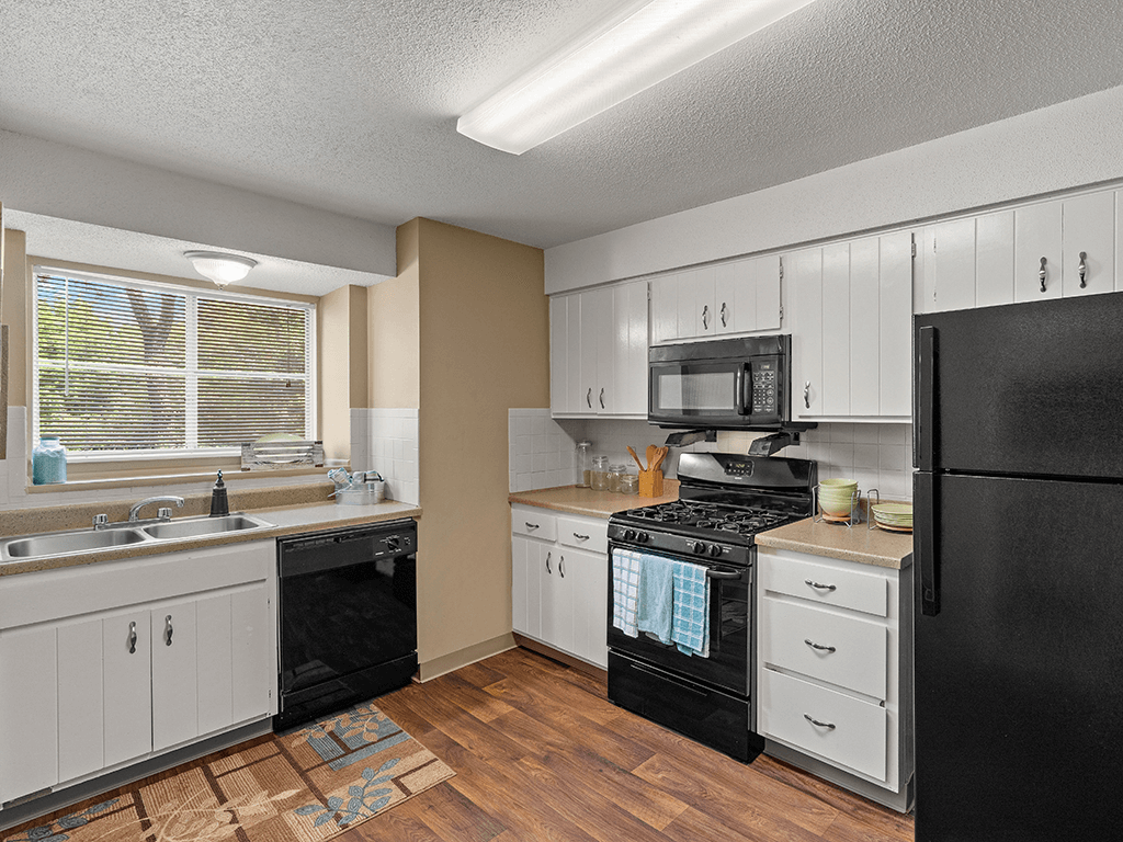 a kitchen with black appliances and white cabinets