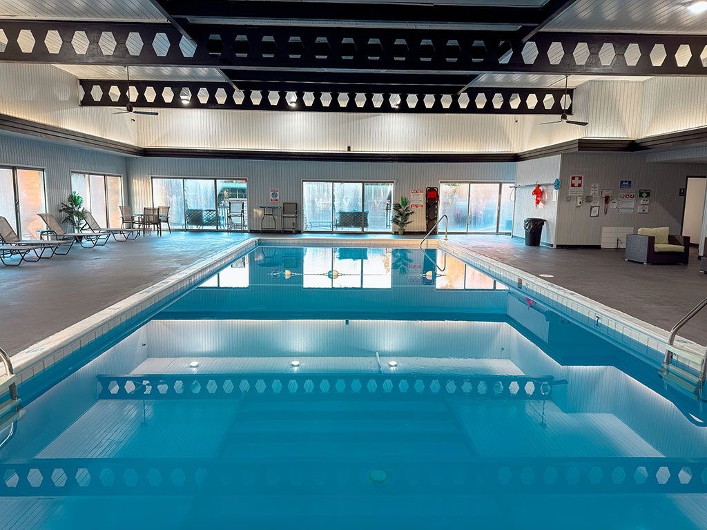 A large indoor swimming pool with a sunken seating area.