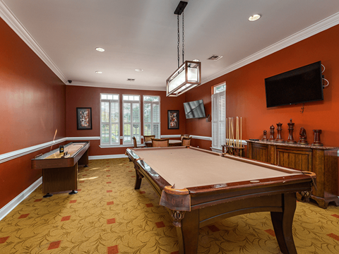 A pool table in a room with orange walls.