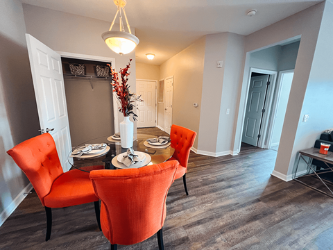 A dining room with a table set for two and two chairs.