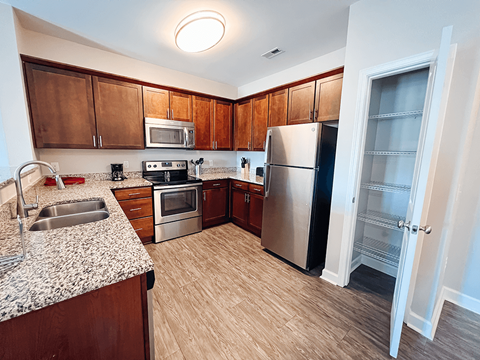 A kitchen with wooden cabinets and a refrigerator.