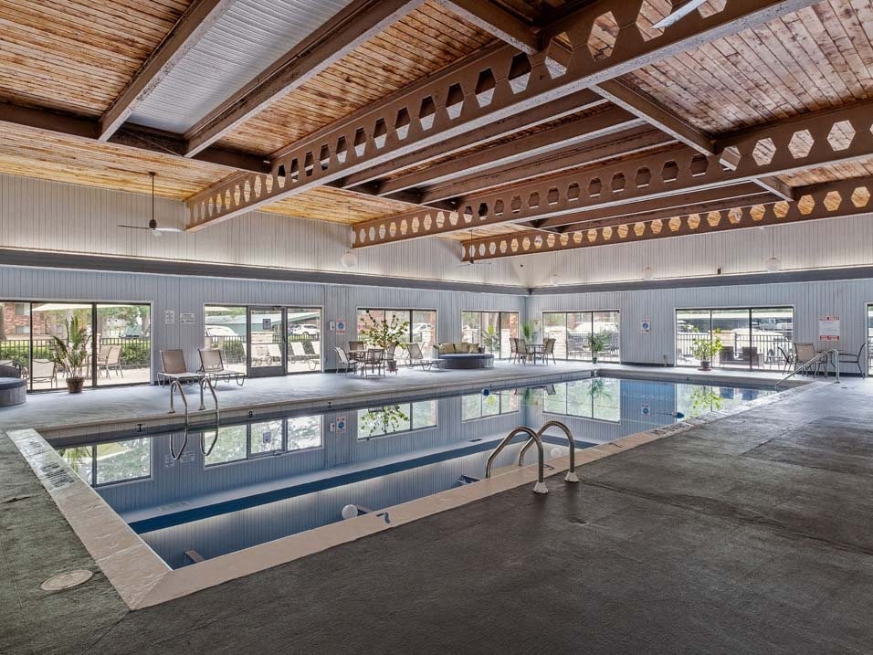 a large indoor swimming pool with a wooden ceiling