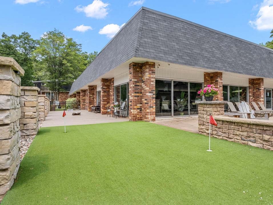 a backyard with a lawn and a building in the background