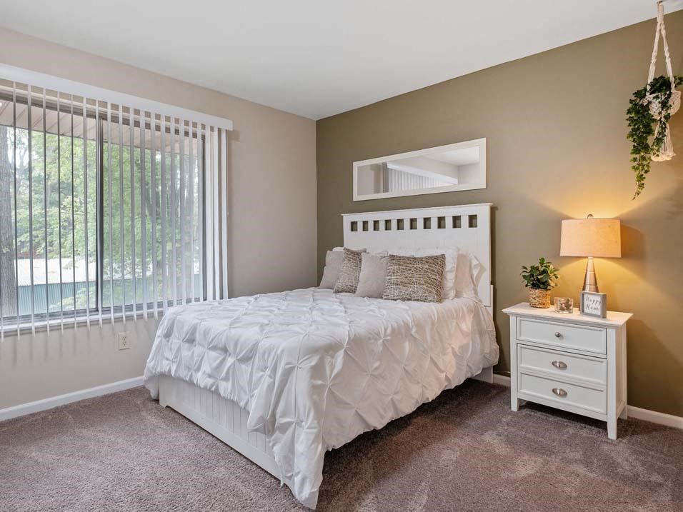 a bedroom with a bed next to a window