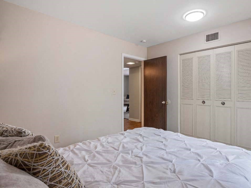 a bedroom with a large bed and a door to a bathroom