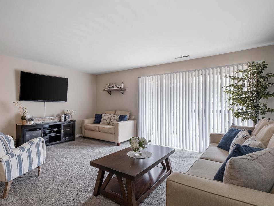 a living room filled with furniture and a flat screen tv