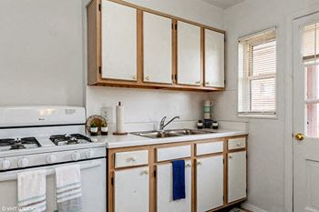 a kitchen with white appliances and wooden cabinets