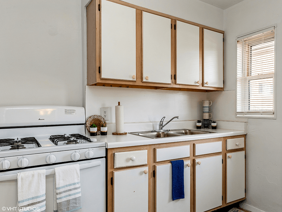 apartment kitchen with white appliances and cabinets