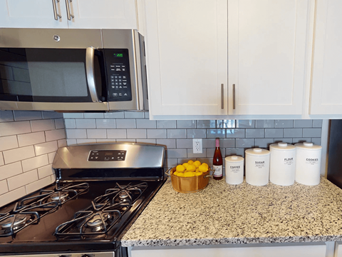 a kitchen counter with a stove and a microwave
