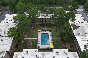 A pool surrounded by trees and concrete structures.
