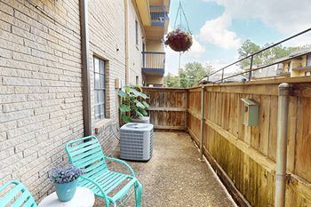 A balcony with a table and two chairs.
