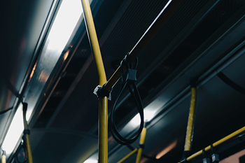 A close up of a yellow hand rail on a bus.