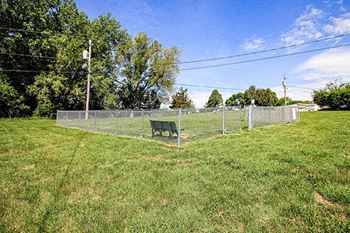 a park bench next to a fence in a field
