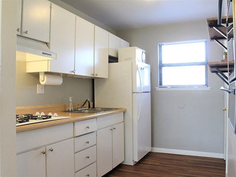a kitchen with white cabinets and a refrigerator