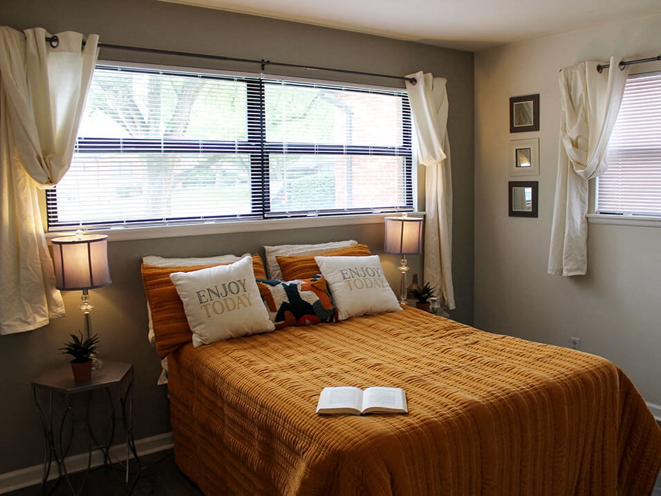 apartment bedroom with a bed and a window