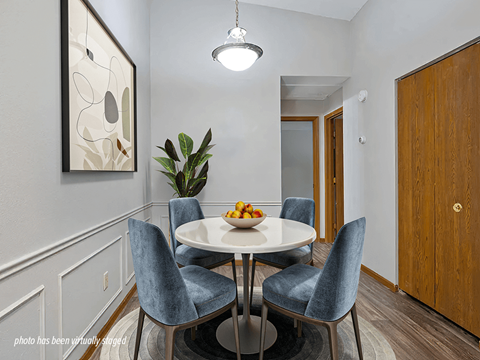 A dining room with a white table and blue chairs.