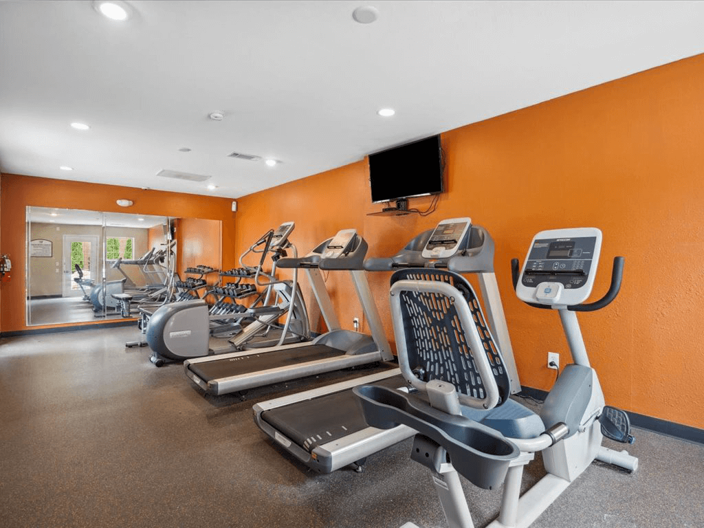 a gym with cardio equipment and weights at apartment complex