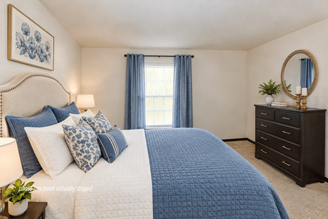 A bedroom with a large bed and a dresser.