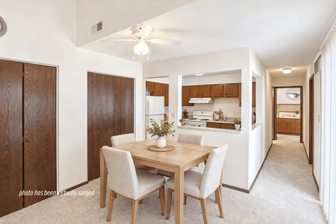 A dining room with a table and chairs.