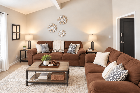 A living room with brown couches and a glass coffee table.