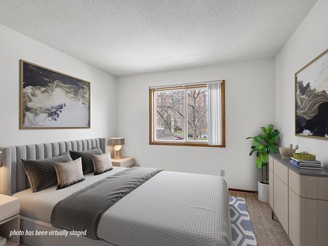 A bedroom with a large bed and a painting on the wall.