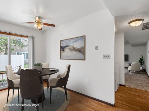 A dining room with a table and chairs.