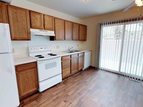 A kitchen with wooden cabinets and white appliances.